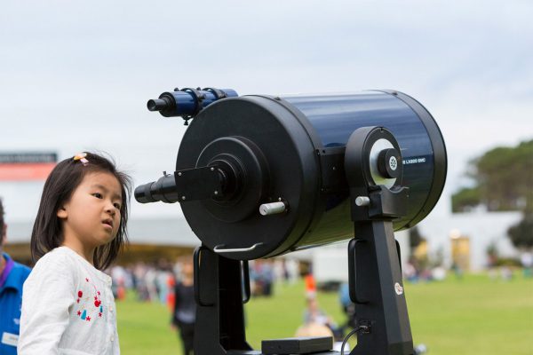 A young girl looking through our Meade 12 inch telescope. Image Credit: Astrofest