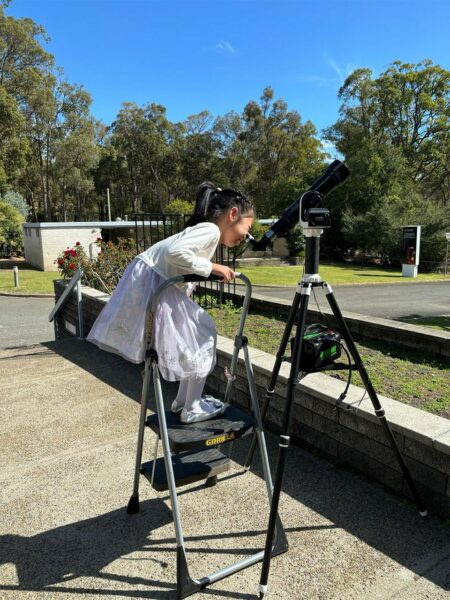 Child looking through a solar telescope. Image Credit: Park Liu